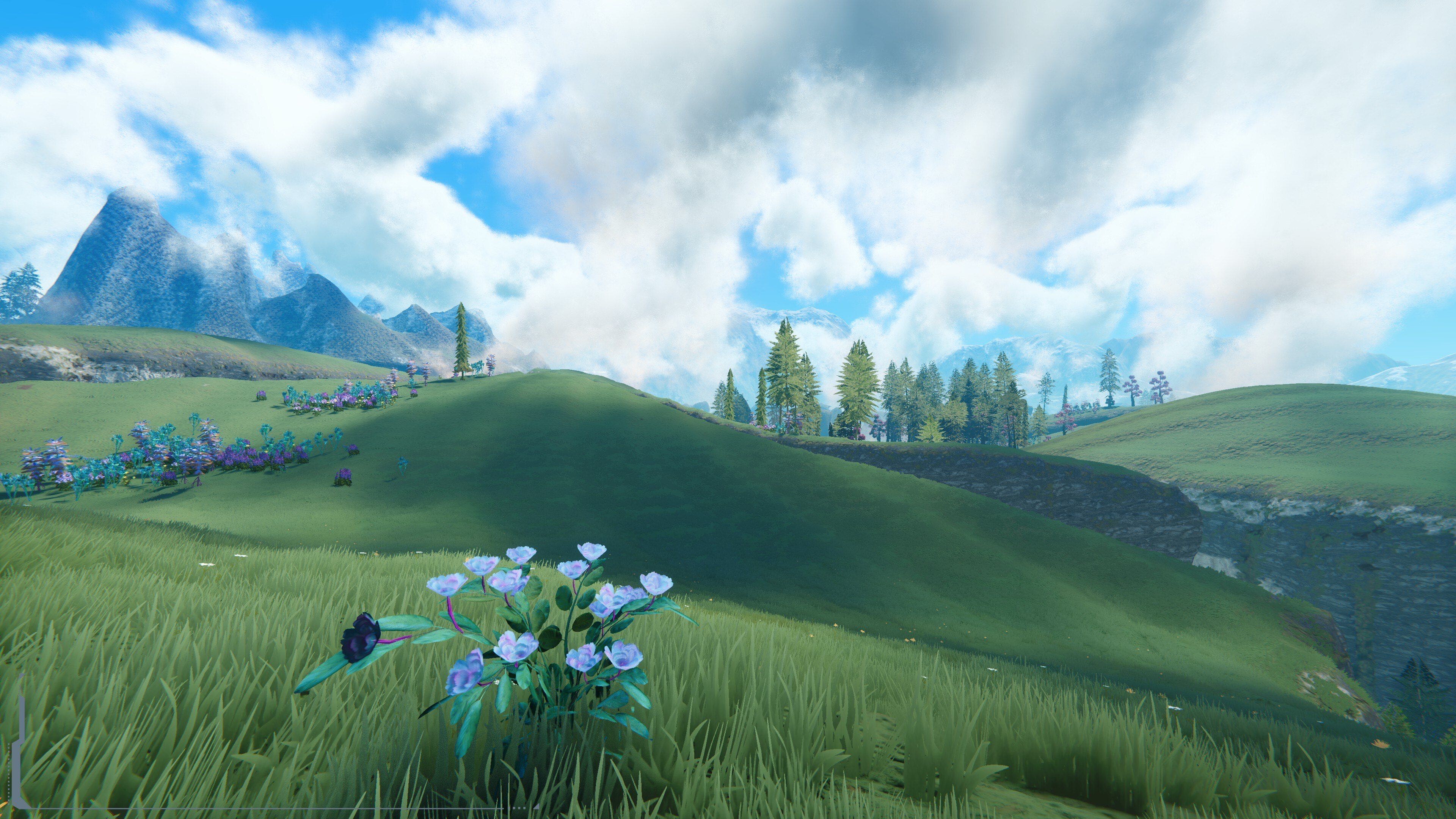 Purple flowers on rolling green hills beneath mountains and a cloud-filled blue sky.